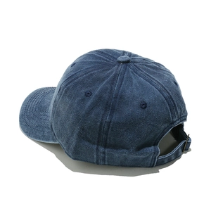 Detail of washed cotton baseball cap featuring vintage texture and adjustable metal buckle