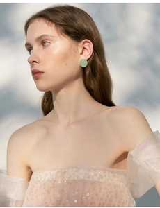 Close-up of model wearing green round aventurine earrings with S925 silver needles