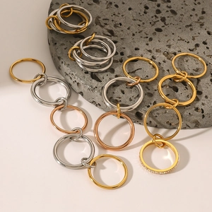 Stackable stainless steel rings in gold, silver, and rose gold finishes on stone base