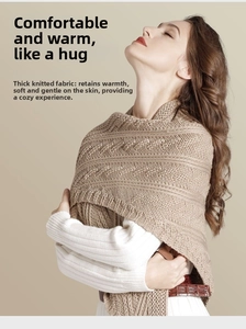 Close-up of light brown knitted shawl showing thick cable knit texture and weave patterns