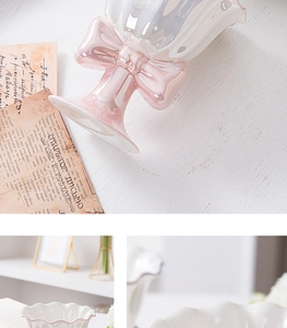 Close-up of pink and white ceramic dessert goblet with a large bow detail on a vintage desk