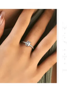 Close-up of emerald cut cubic zirconia ring with pavé setting on green fabric