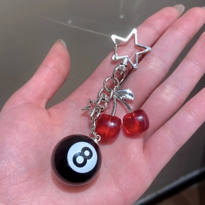 Detail of red cherry billiard 8 ball keychain with silver stars and sleek metal clips