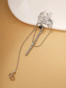 Detailed view of silver ear cuff featuring long chain tassels with rhinestones and beads