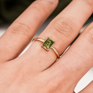 Detailed macro view of a vintage gold ring featuring a rectangular green moss agate stone