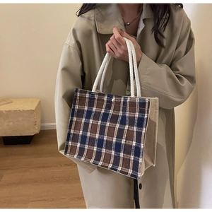 Detail view of canvas tote bag with brown plaid pattern and sturdy white rope handles