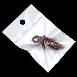 Vintage amethyst ice cream pendant wrapped in copper wire, presented on a black background