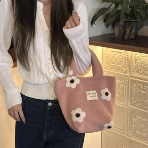 Close-up of pink plush tote bag with white flower patterns and sozakka label detail