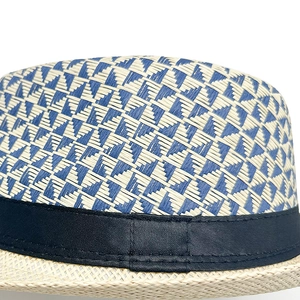 Close-up of blue and white geometric woven texture on straw fedora with black ribbon