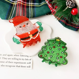 Detailed shot of Christmas hair claw clips with Santa and tree motifs on a festive tray