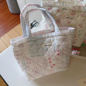 Detail of quilted cotton tote bag with floral pattern and simple wish label