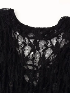 Détail en gros plan de la texture dentelle florale et du tissu maille noir du haut à manches