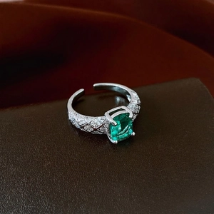 Anello aperto con zircone smeraldo rettangolare e motivi trapuntati su fascia d'argento