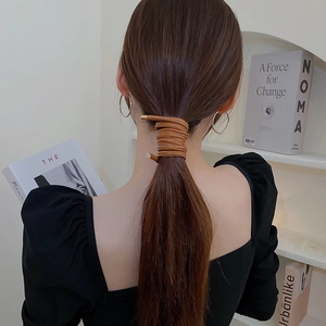 Brown faux leather hair wrap accessory shown on a model's ponytail for a sleek style