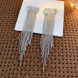 Sparkling silver heart drop earrings with long rhinestone tassels on a classic display card