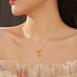 Detail of 18k gold plated four-leaf clover necklace with sparkling cubic zirconia on neck