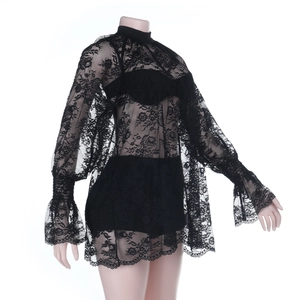 Close-up of black lace high-neck top with ruffled cuffs and intricate hollow patterns