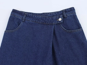 Gros plan d'un jean bleu foncé à taille haute avec ceinture asymétrique superposée