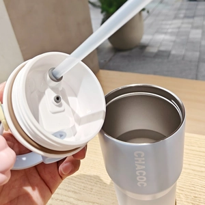 Detail of the stainless steel coffee cup lid featuring a leak-proof straw interface and handle
