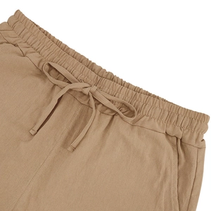Detail of khaki linen shorts featuring elastic drawstring waistband and breathable fabric