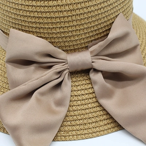 Détails macro d'un chapeau de paille tressé avec un grand nœud en mousseline élégant