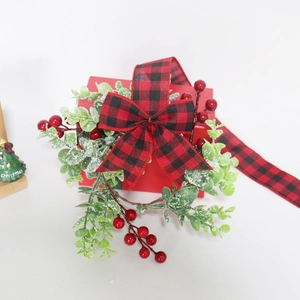 Christmas gift box with red berries, eucalyptus, and buffalo plaid bow decoration