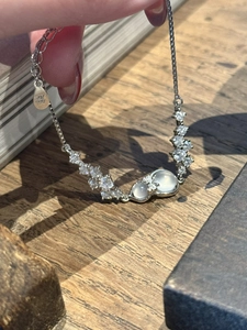 Detail of S925 silver bracelet with zirconia bow, gourd pendant and white stones