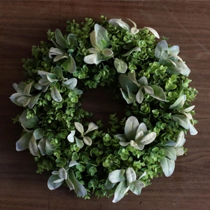 Artificial spring eucalyptus and boxwood wreath for door decor on dark wood background