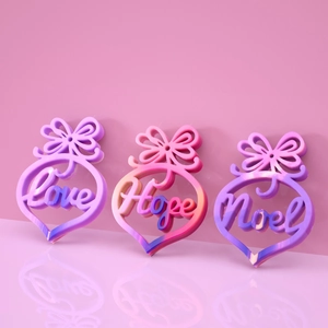 Close-up of 3D heart-shaped resin charms with bows and Love Hope Noel text engravings