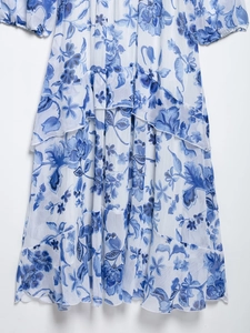 Detail of blue floral chiffon dress showing tiered ruffled hem with bohemian pattern