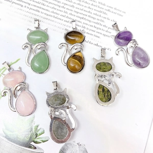 Set of six alloy cat pendants with various natural crystal stones on a vintage book