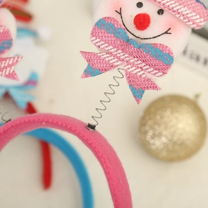 Close-up of pink velvet headband with snowman figure and metallic spring detail