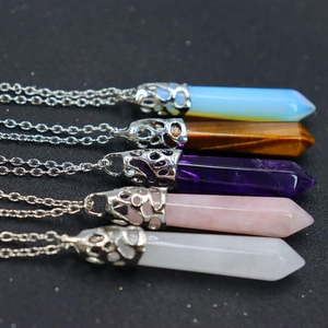 Detail of diverse hexagonal crystal pendants including opal, tiger eye and amethyst