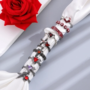 8-piece dark gothic ring set with red heart, cross, and bats on white silk cloth