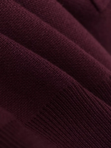 Detailed macro view of burgundy polo knitwear featuring fine texture and ribbed hem