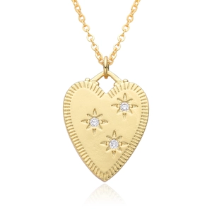 Macro shot of 18K gold heart pendant necklace featuring sparkling star-set cubic zirconia