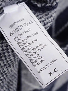 Detailed care label showing 100% polyester material and washing instructions on knitwear