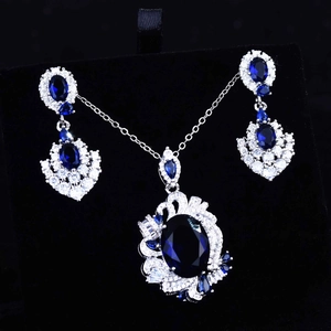Detailed close-up of luxury royal blue sapphire necklace and earrings with diamond accents
