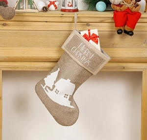 Linen Christmas stocking with Merry Christmas print hanging on a decorated mantel