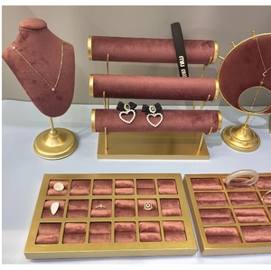 Detail of burgundy velvet jewelry display stands with gold frames for rings and necklaces
