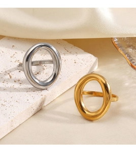 Macro shot of 18K gold and silver hollow oval rings on white textured stone background