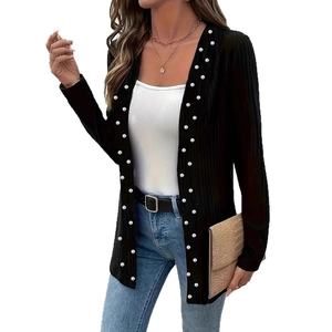 Detailed close-up of elegant black knitted jacket featuring premium pearl bead embellishments