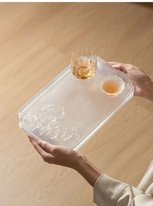 Detailed view of square crystal glass tea tray with embossed fruit patterns and two cups