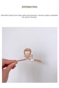 Detail view of gold flower hair claw clip with rhinestones and white pearl dangle