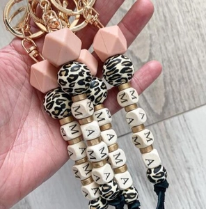 Detail of MAMA silicone bead keychain with leopard print and pink geometric accents