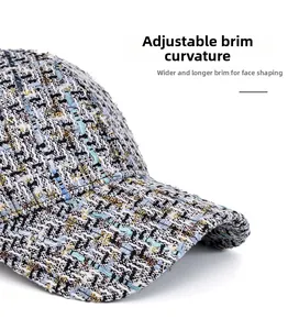 Close-up of tweed baseball cap brim with blue and white woven texture and curved design