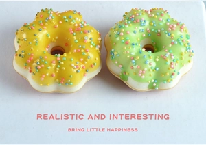 Detail of yellow and green artificial donuts with colorful sprinkles on marble background