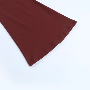 Detail view of burgundy slim jumpsuit showing flared leg cuff and durable stitching