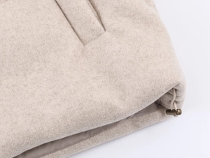 Detail of beige wool coat featuring adjustable drawstring toggle and smooth inner lining