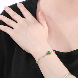 Close-up of gold heart bracelet with green malachite texture and pavé crystals on wrist